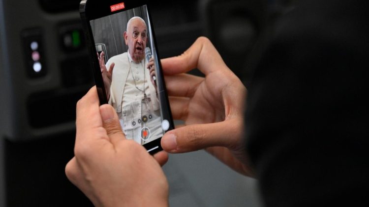 Francisco filmado por jornalistas durante a coletiva de imprensa no avião papal