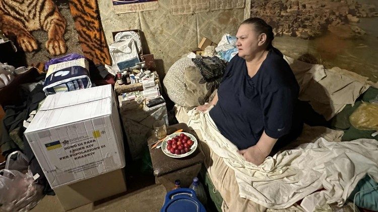 Uma mulher recebe em sua casa uma cesta básica, presente do Papa