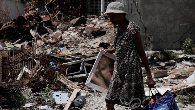 Mulher haitiana retorna a casa depois que uma das gangues se retirou do território.