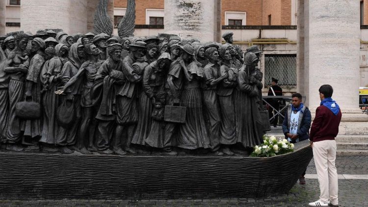 Migrantes prestam homenagem à escultura a eles dedicada na Praça São Pedro